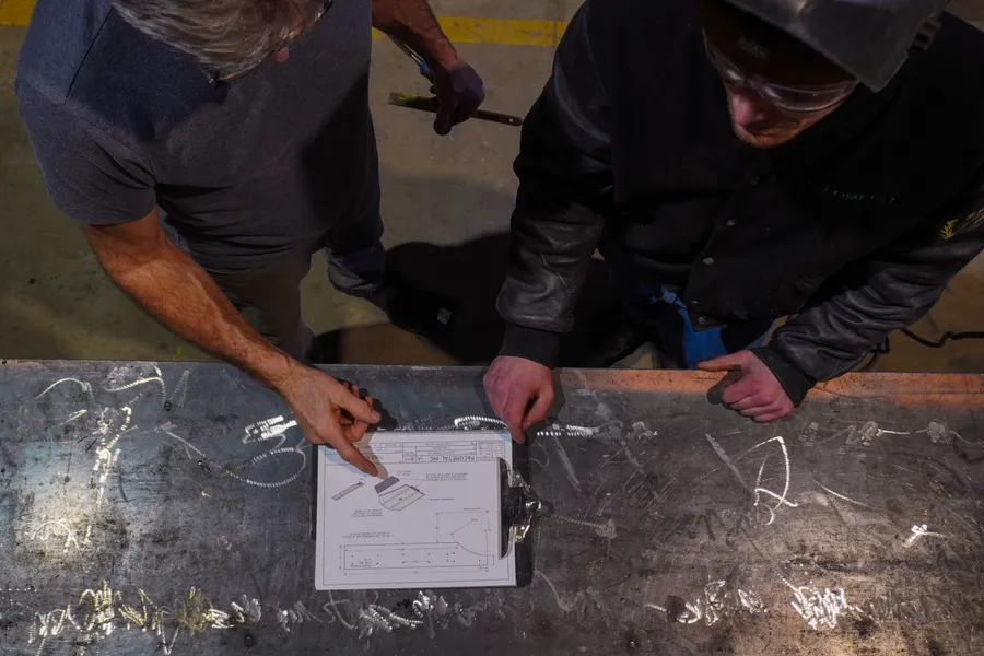 Revue d’un plan avec le client sur la table d’atelier